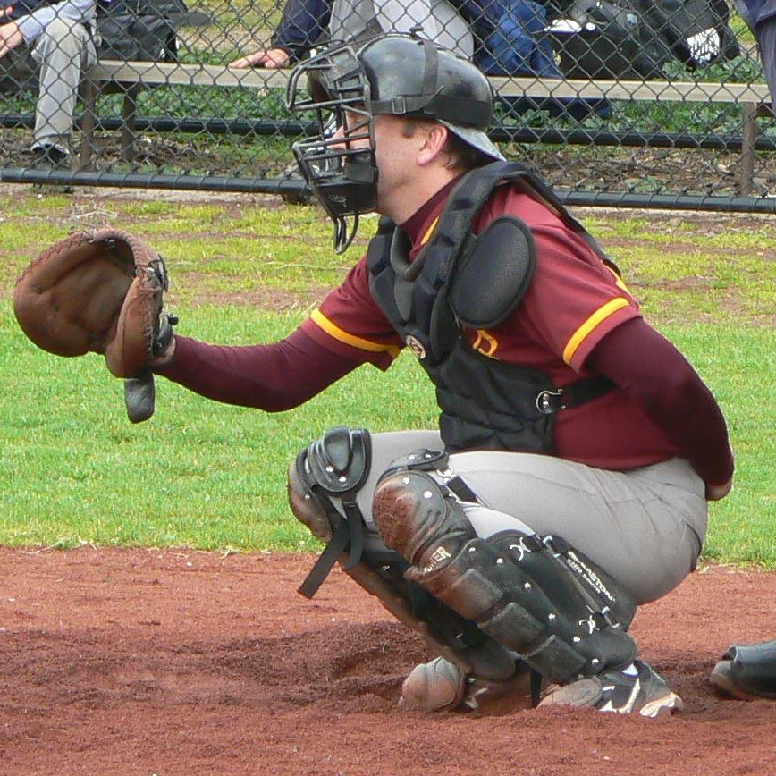 Image of a man squatting and wearing protective baseball equipment